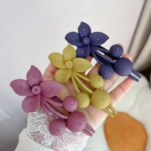 Matte floral hair clips with rhinestones in purple, yellow, and pink colors