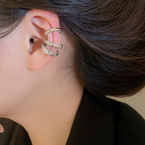 Detail of silver heart ear cuff with sparkling zircon stones in a three-layer stacked design