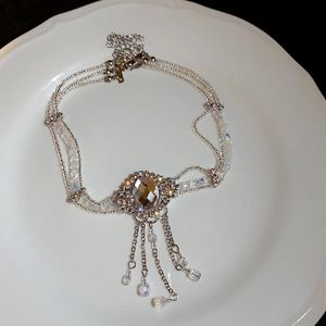 Détail d'un collier de perles en cristal à plusieurs rangs avec pierres et glands