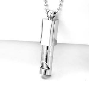 Macro detail of silver titanium steel meditation whistle pendant with 528 Hz engraving