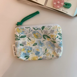 Detail of green floral cotton coin purse with simple wish label and woven zipper pull