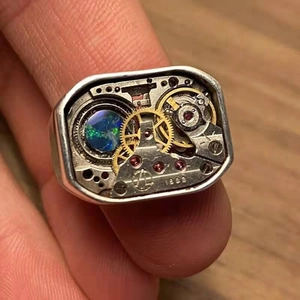 Close-up of vintage steampunk ring with mechanical gears and blue opal inlay