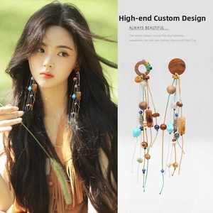 Detailed view of long bohemian tassel earrings with wooden beads and turquoise accents