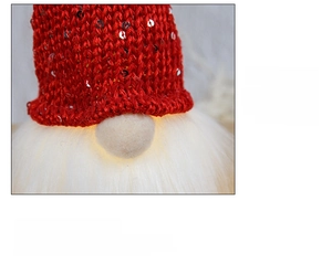 Detail of a glowing Christmas gnome with red sequined hat and warm lighted nose