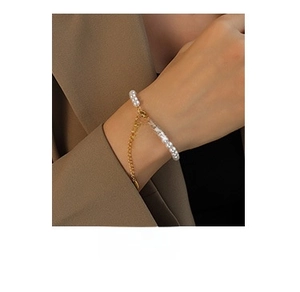 Detail of elegant gold-plated titanium necklace with white pearls and round pendant