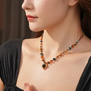 Bohemian beaded heart necklace with turquoise accents and lava gold pendant on a model