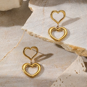 Detail view of double layered hollow heart drop earrings with 18K gold plated finish
