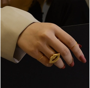 Detail of 18K gold plated lip design ring with minimalist band on hand model