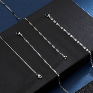 Detailed view of silver stainless steel cross chains with lobster clasps on display