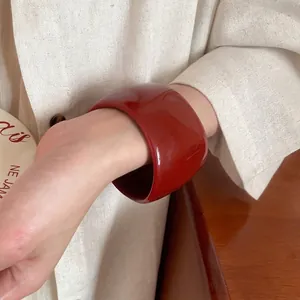 Irregular wide red resin bangle bracelet with glossy finish for a retro minimalist look