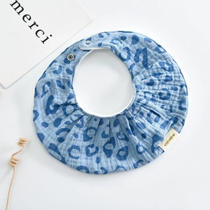 Detail of blue leopard print cotton baby bib with snap button and miomimio label