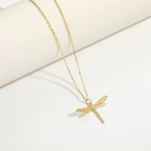Macro view of gold dragonfly pendant necklace with sparkling white cubic zirconia stones