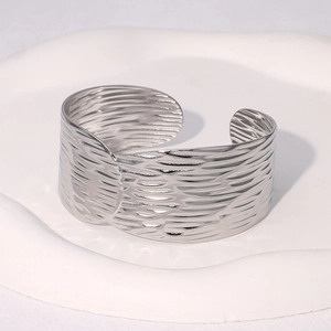 Detailed view of silver wavy textured wide cuff bracelet with a polished finish