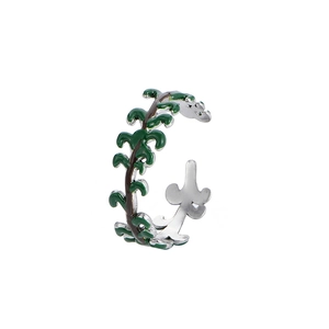 Detail of silver branch ring with green vine pattern and brown stem on white background