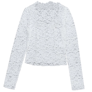 Détail du motif en dentelle florale et bordure festonnée sur ce haut blanc