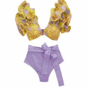 Close-up of floral print V-neck bikini top with ruffle shoulders and purple bow bottoms