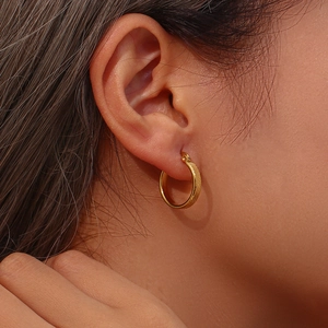 Detailed close-up of 20mm gold-plated stainless steel hoop earring worn on an earlobe