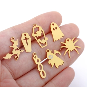 Macro shot of gold stainless steel Halloween charms like witches and ghosts held in hand