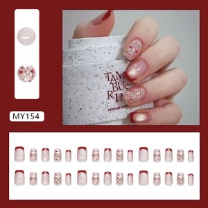 Red French tip press-on nails with floral gold foil and shimmering pearl cat eye finish