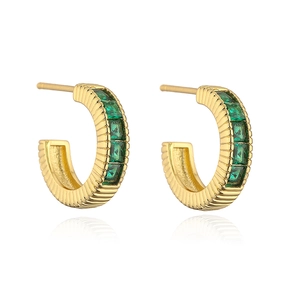 Close-up of gold-plated C-shaped earrings with inlaid green rectangular zircons