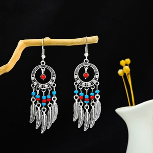 Détail de boucles d'oreilles attrape-rêves bohèmes avec perles turquoise et plumes