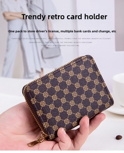 Detail of vintage brown textured card wallet with golden clover patterns and zipper