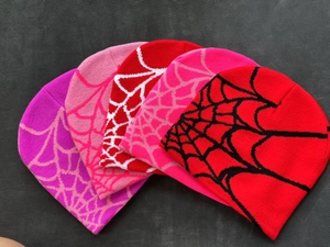Detailed view of colorful knitted beanies featuring high-density spider web jacquard patterns