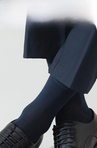 Detail of navy blue mesh socks worn with leather shoes and dress pants for men