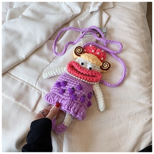 Detail of a purple handmade crochet crossbody bag with pearl decor and woven strap