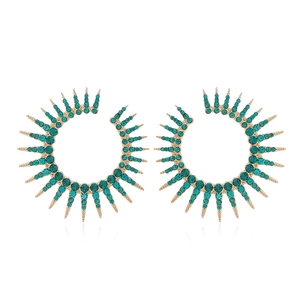 Modern gold sunburst earrings with radiant green crystal accents on a white background
