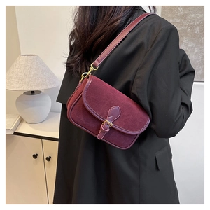 Detail of wine red shoulder bag showing premium suede and leather patchwork with gold buckle