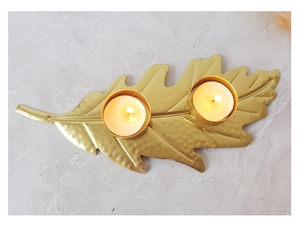 Detail of golden leaf candle holder with hammer texture and dual tea light slots
