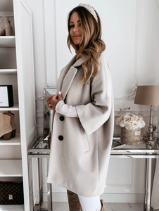 Gros plan sur le manteau en laine beige avec revers classique et détails de boutons