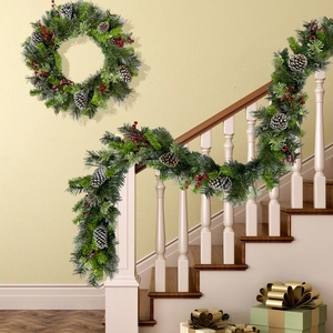 Christmas wreath and pine garland with red berries on staircase and beige wall decoration