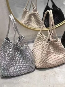Minimalist hand-woven dumpling handbag in silver and beige with knotted leather handles