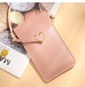 Detail of crossbody phone bag in pink PU leather with golden heart buckle decoration