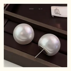 Macro shot of large 14mm white pearls with iridescent luster on a dark jewelry tray