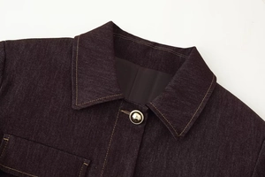 Détail de la veste en sergé avec surpiqûres jaunes et boutons métalliques polis