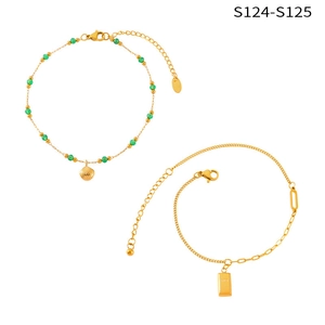 Detailed shot of titanium steel anklets with green beads, shell and gold brick charms