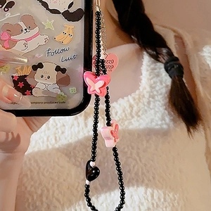 Detail of black beaded phone strap with pink butterfly and heart charm on cartoon case