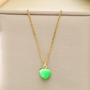 Detailed macro view of a green enamel apple pendant on a golden stainless steel chain