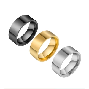 Polished titanium steel rings in black, gold and silver finishes on a white background
