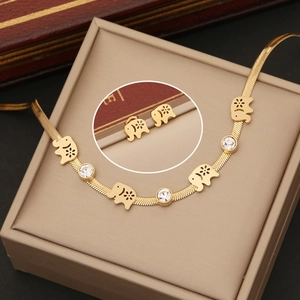 Détail d'un ensemble de bijoux éléphant doré avec motifs fleurs et pierres de zircon
