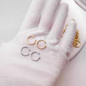 Detail showing S925 sterling silver ear cuffs in gold and silver finishes on gloved hand