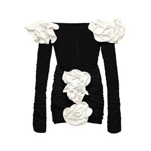Detail of 3D white floral applique on an off-shoulder long sleeve black mini dress