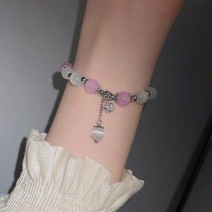 Detailansicht eines Armbands aus rosa und opalen Perlen mit silbernem Sternanhänger