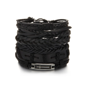 Detail of multi-layer black leather bracelet set featuring a metallic cross plate