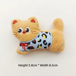 Detail of plush cat charm with leopard print outfit, measuring 5.8cm height by 8.5cm width