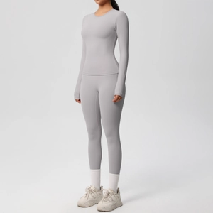 Dettaglio del set yoga grigio con maglia a maniche lunghe, fori per i pollici e leggings a vita alta