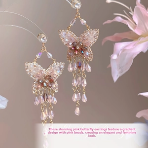 Détail de boucles d'oreilles papillon avec zircons roses et longs pompons élégants